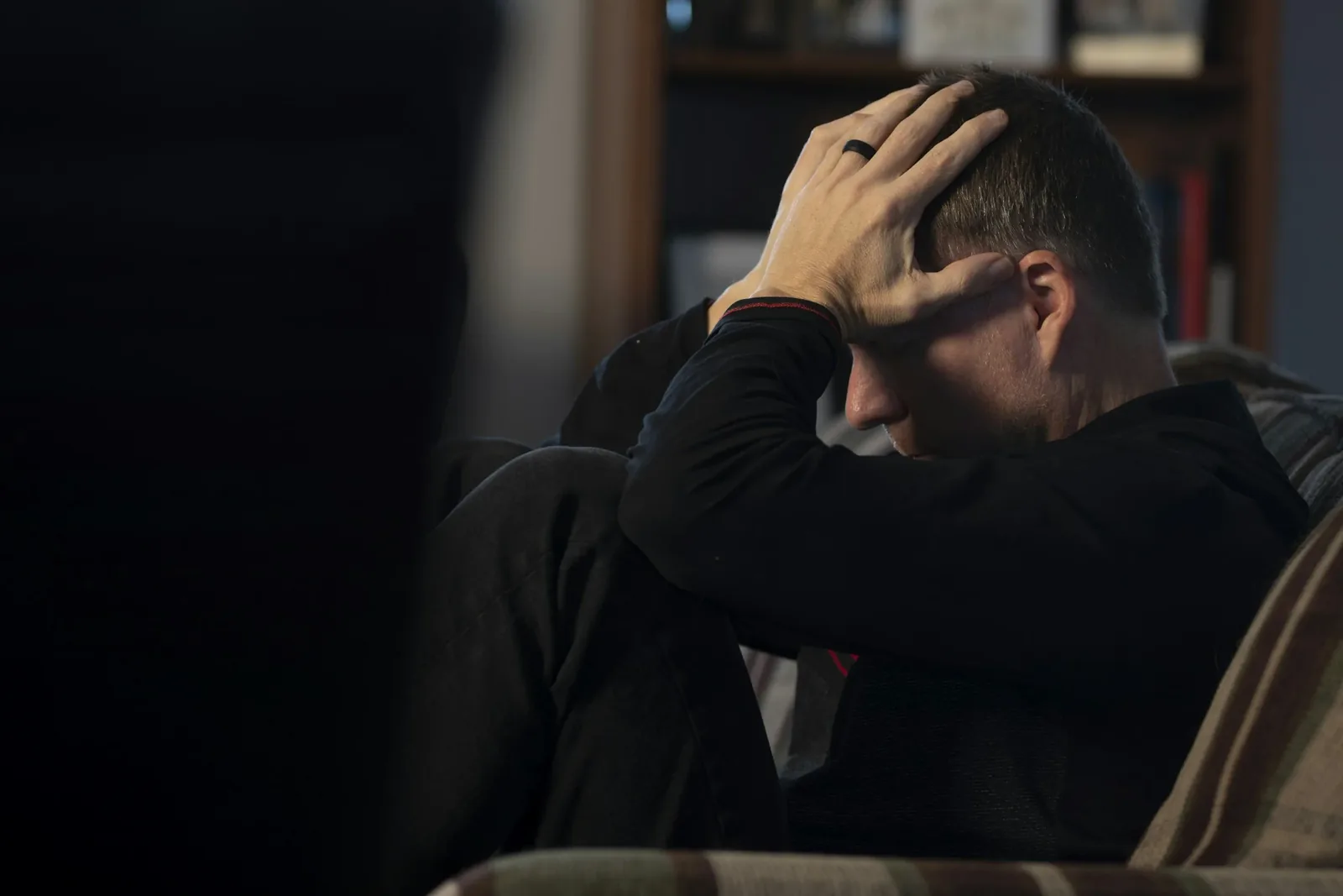 Frustrated person holding their head, overwhelmed by feeling stuck and unable to move forward, as described in the blog about breaking free from dissatisfaction, setting meaningful goals, and manifesting personal growth.