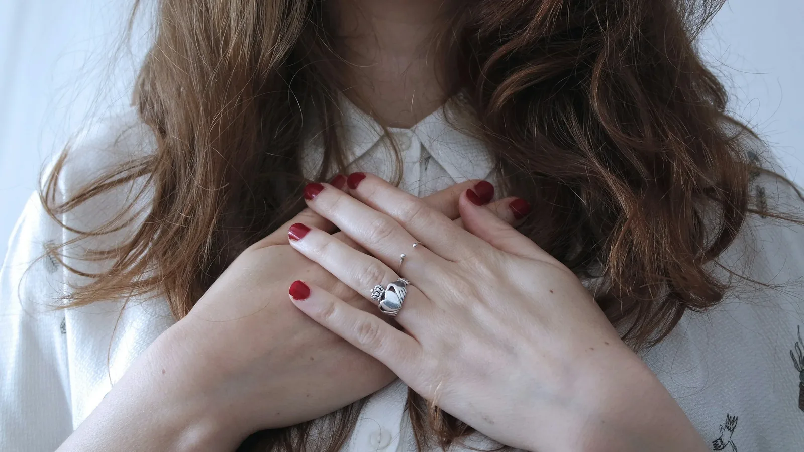 A woman resting her hands over her heart