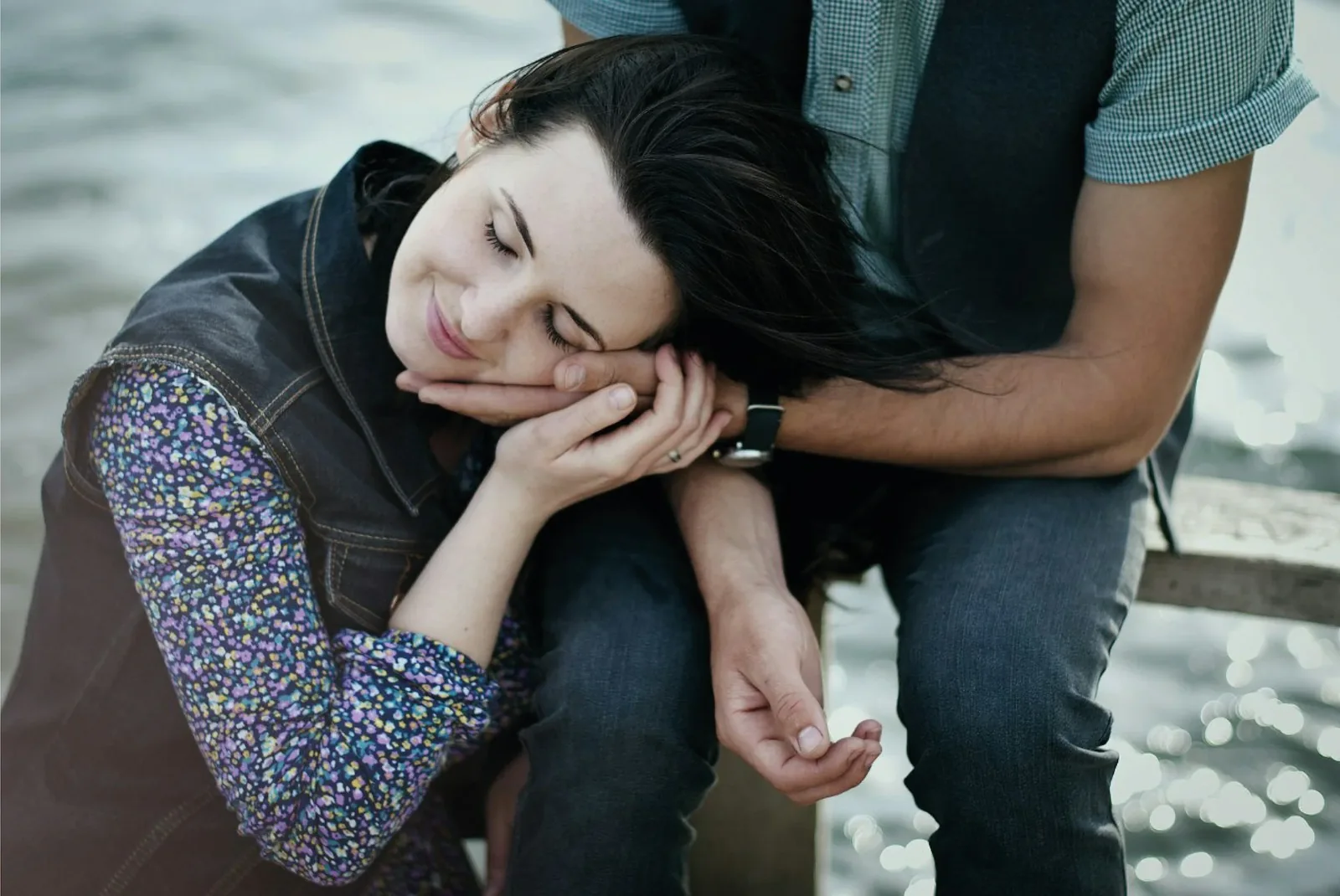 A couple sitting close, her head resting on his shoulder